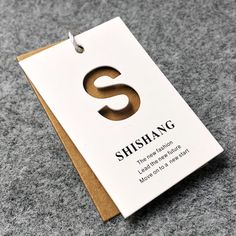 a card with the letter s on it sitting on top of a gray carpeted floor