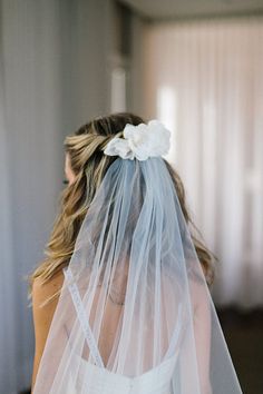 the back of a bride's veil with flowers on it