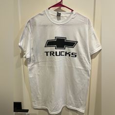 a white t - shirt with the words trucks on it hanging from a hanger