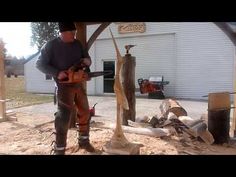 a man with a chainsaw standing next to a tree in front of a building