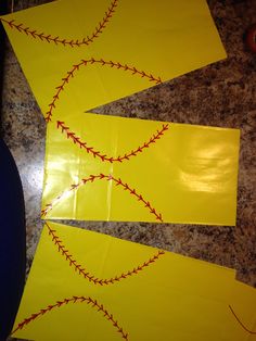 three pieces of yellow paper with red stitching on them