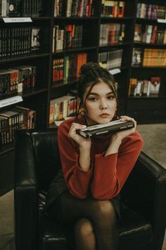 a woman sitting in a chair holding a remote control