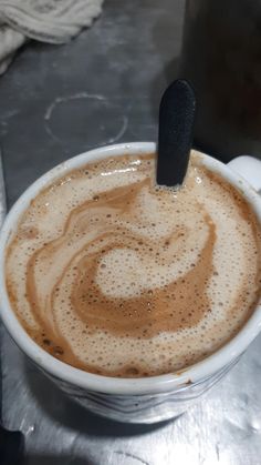 a cup of coffee with a spoon sticking out of it