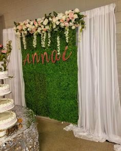 an arrangement of flowers and greenery is displayed in front of a backdrop with the word annoa