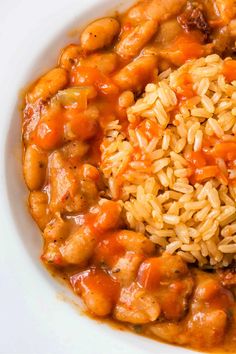 a white plate topped with rice and meat covered in gravy