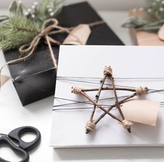 a gift wrapped in twine and tied with twine is sitting on a table next to scissors