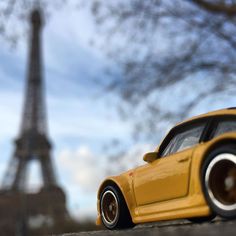 a toy car is parked in front of the eiffel tower