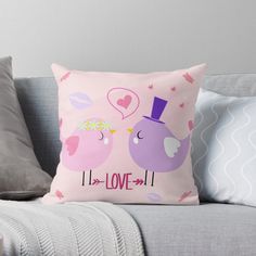 a pink pillow with two birds on it and the words love is written in black