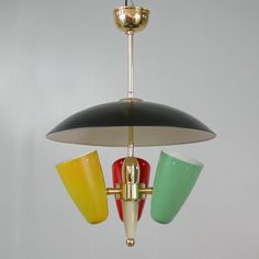 a multi - colored light fixture with three cups hanging from it's side and two lights attached to the ceiling