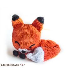 an orange knitted fox laying on its side