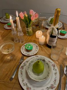 a wooden table topped with plates and silverware