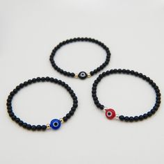 Crafted with sleek small black onyx beads, this bracelet features a striking evil eye bead at its center. Symbolizing protection and warding off negative energy, the evil eye adds both meaning and style to this design. A great addition to your stack + a little protection. Created with 4mm black onyx beads and your choice of a red, blue or black evil eye bead in the center. Choice of Sterling Silver or 14k Gold Filled accent beads. Easy wear and effortless bracelet stacking with stretch cord desi Black Evil Eye, Bracelet Stacking, Chains Necklaces, Onyx Bead, Eye Bracelet, Evil Eye Bracelet, Pendant Bracelet, Fall Shopping, Bracelet Stack