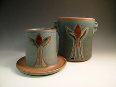 two cups and saucers with designs on them