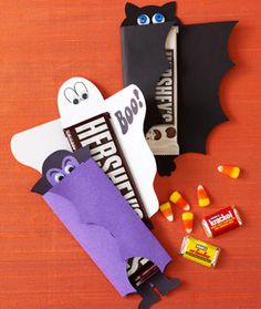 halloween treat bags and candy on a wooden table with bats, bat and tombstones