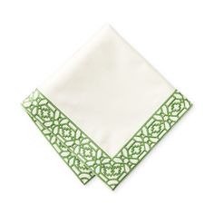 a green and white napkin with an intricate design on it's edge, folded in two