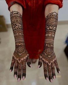 a woman's hands with hennap on her arm and hand, showing the intricate