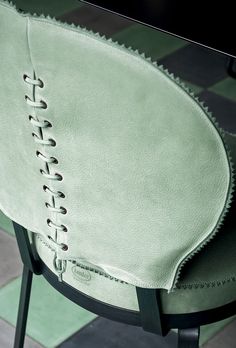 the back of a green chair with laces on it's seat and side