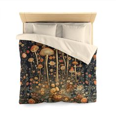 a bed covered in a comforter with mushrooms and flowers all over it's surface