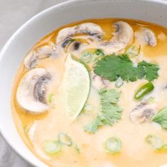 a bowl of soup with mushrooms and cilantro