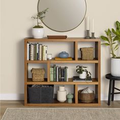 a bookshelf with various items and a round mirror on the wall