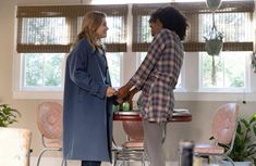 two women shaking hands in front of a table