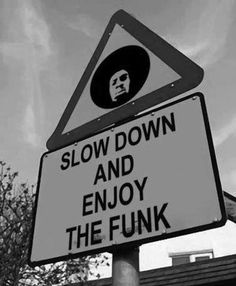 a street sign that says slow down and enjoy the funky one with a man's face on it