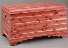 a large wooden chest sitting on top of a gray floor next to a white wall