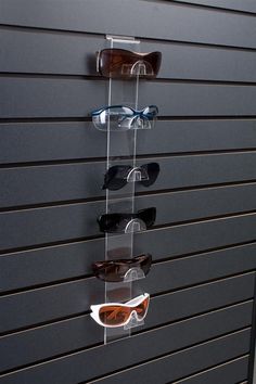 several pairs of sunglasses are hanging on a wall in front of a pair of glasses