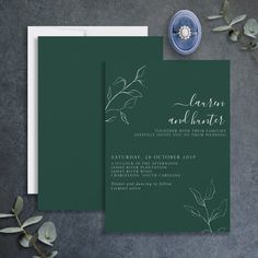 the wedding stationery is set on top of a table with greenery and flowers