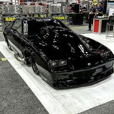 a black car is on display in a showroom