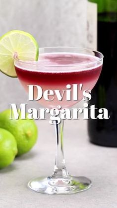 devil's margarita in a coupe glass with limes next to it