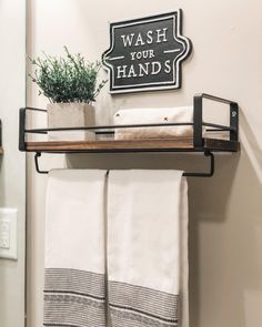 a towel rack with two white towels and a potted plant on top of it