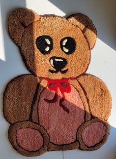 a teddy bear rug with a red bow on it