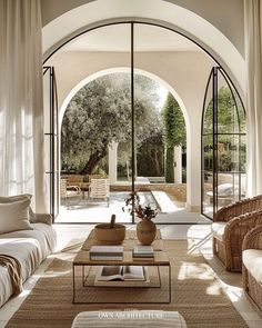 a living room filled with lots of furniture and an archway leading to the outside patio