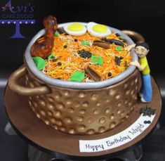 a birthday cake made to look like a pot full of noodles and eggs with a man standing on top