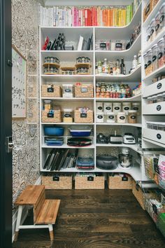 an organized pantry with lots of shelves and bins filled with food, books, and other items