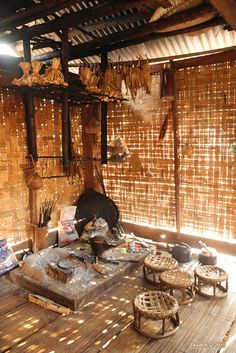 a room with bamboo walls and flooring, including stools and other items on the table