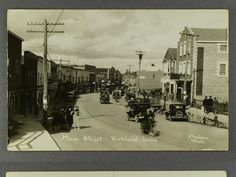 an old black and white photo of cars driving down the street