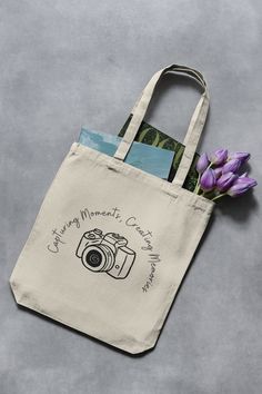 "Elevate the journey of every snapshot with our \"Capturing Moments, Creating Memories\" photography-themed tote bag. Crafted from durable cotton canvas, this stylish carrier is a must-have for shutterbugs who capture life's moments one frame at a time. Perfect for carrying essential photography gear or daily essentials, this tote bag blends functionality with a touch of artistry. Gift the photographer in your life a chic and meaningful accessory that echoes their passion for storytelling throug Totebag Photography Ideas, Canvas Bag Photography, Tote Bags Photography, Tote Bag Product Photography, Tote Bag Photography Ideas, Tote Bag Photoshoot, Bag Photography Ideas, Bag Product Photography, Tote Bag Photography