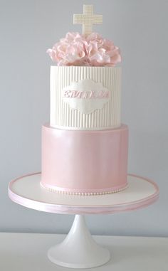 a pink and white cake with flowers on top