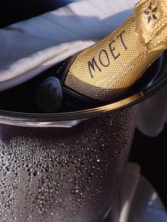 a close up of a champagne bottle in a glass container with the word moet written on it