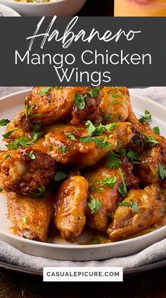 chicken wings with cilantro and parsley on the side in a white plate