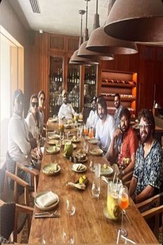 a group of people sitting around a wooden table