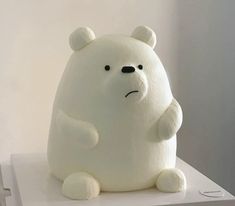 a white stuffed bear sitting on top of a table