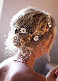 a woman with flowers in her hair is looking into the mirror while wearing a wedding dress