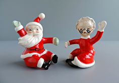 two santa claus figurines sitting next to each other