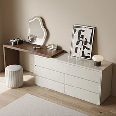 a white dresser sitting next to a mirror on top of a wooden table