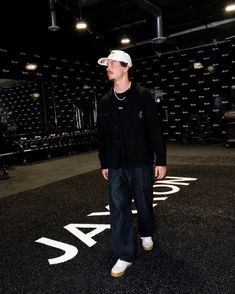 a man standing in the middle of a room with black and white letters on it