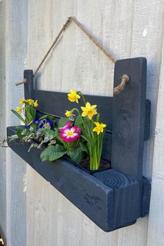 a wooden shelf with flowers hanging from it