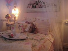 a teddy bear is sitting on a bed with white sheets and pink flowers in the room